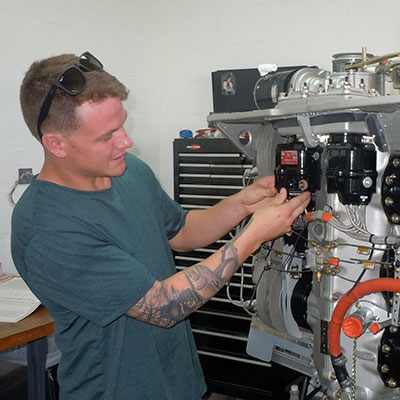 A man working on an engine in a shop.