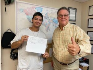 A man and his father holding up a piece of paper.