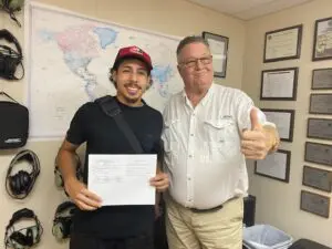 Two men posing with a certificate.