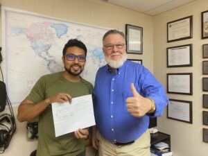 Two men celebrating with a document in office.