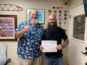 Two men celebrating with a document in hand.