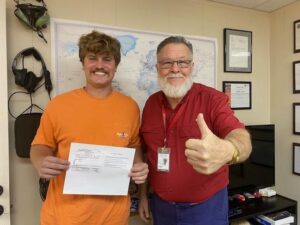 Two men celebrating achievement with paperwork.