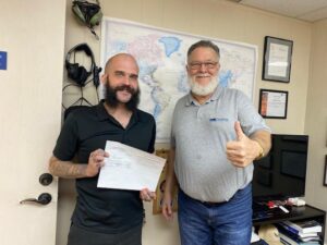 Two men celebrating with a document and smiles.
